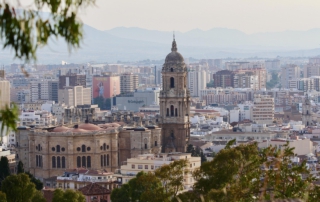 Panoramablick auf die Stadt Málaga in Andalusien, mit der Kathedrale und modernen Gebäuden in der Skyline.